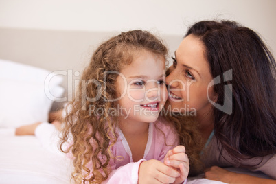 Mother whispering into her daughters ear