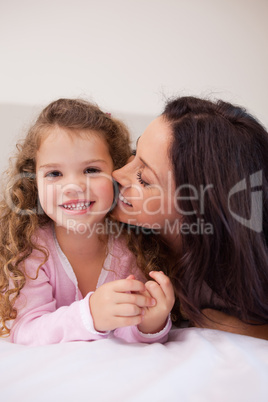Mother kissing her daughters cheek