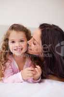 Mother kissing her daughters cheek