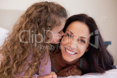 Little daughter giving her mother a kiss