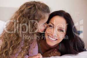 Little daughter giving her mother a kiss