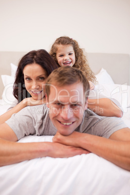 Family relaxing on the bed together