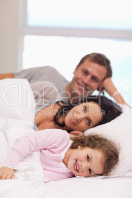 Family lying on the bed together