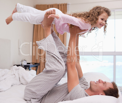 Father playing plane with his daughter