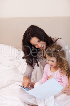 Mother reading bedtime story for her daughter