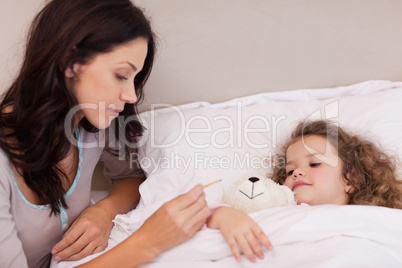 Mother taking her daughters temperature