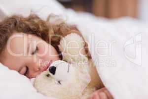 Girl sleeping with her teddy