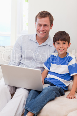 Smiling father and son surfing the internet together
