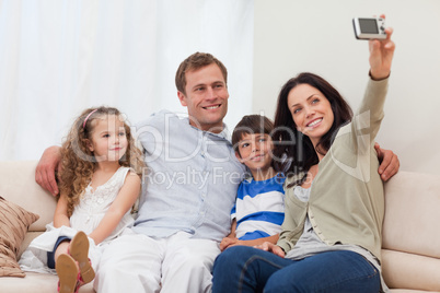 Mother taking a family picture on the sofa