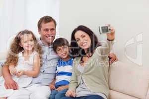 Mother taking family photograph on the couch