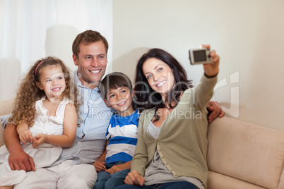 Mother taking family picture in the living room