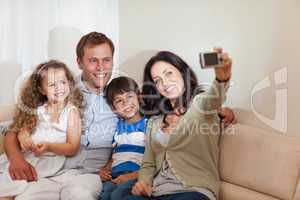 Mother taking family picture in the living room