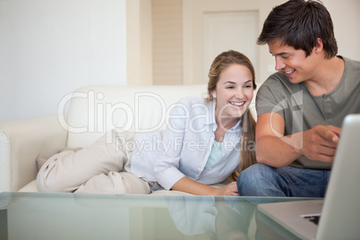 Laughing couple using a notebook