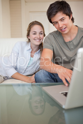 Portrait of a laughing couple using a notebook