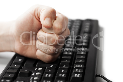 Hand fist on computer keyboard
