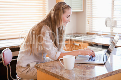 Woman having coffee while using a notebook