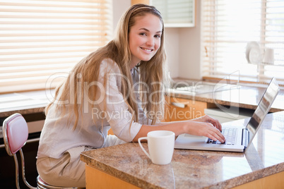 Woman having coffee while using a laptop