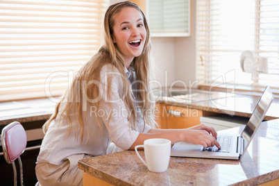 Woman having tea while using a laptop