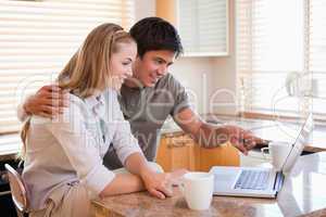 Couple having coffee while using a laptop