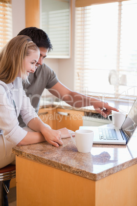 Portrait of a couple having tea while using a laptop