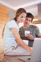 Portrait of a couple having coffee while using a laptop