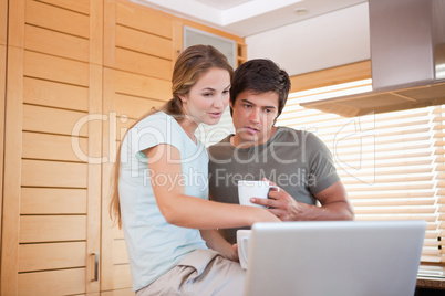 Couple having coffee while using a notebook