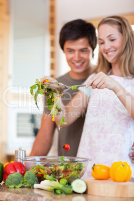 Portrait of a charming couple making a salad