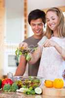 Portrait of a young couple making a salad