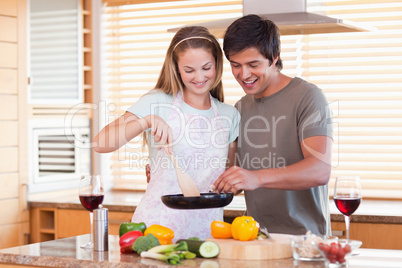 Couple cooking dinner while drinking red wine