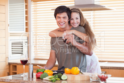 Lovely couple drinking red wine while hugging