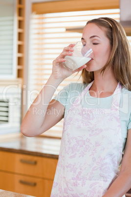 Portrait of a young woman drinking a glass of milk