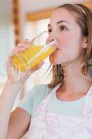 Portrait of a serene woman drinking orange juice