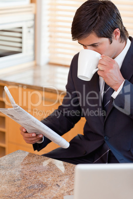 Portrait of a businessman drinking coffee while reading the news