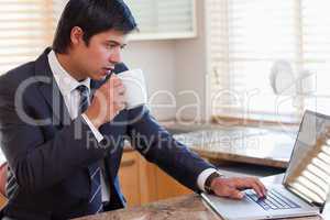 Man working with a notebook while drinking tea
