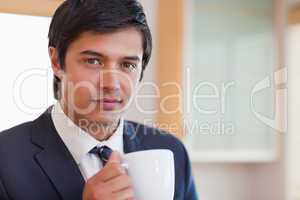 Close up of a handsome businessman drinking coffee