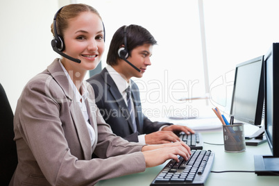 Smiling office workers using computers