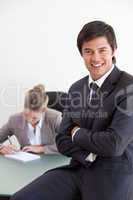 Portrait of an office worker posing while his colleague is worki