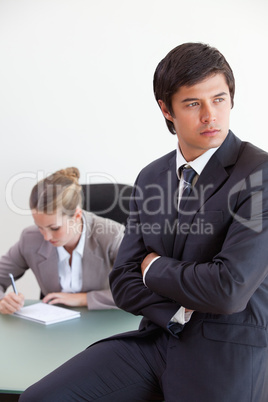 Portrait of a manager posing while his colleague is working