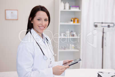 Smiling doctor using a tablet computer