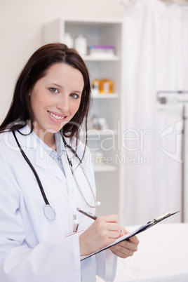 Smiling female doctor taking notes