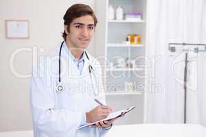 Smiling male doctor with clipboard