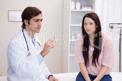 Male doctor preparing injection for patient