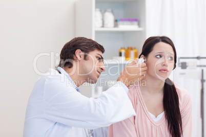 Male doctor examining his patients ear