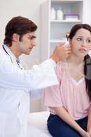 Doctor examining his patients ear