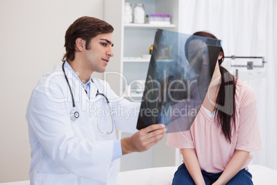 Doctor analyzing x-ray with his patient