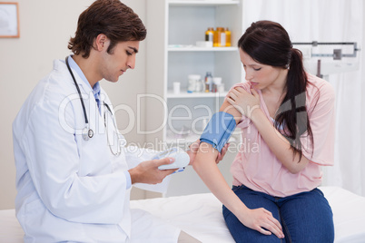 Doctor taking patients blood pressure