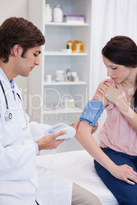 Doctor analyzing patients blood pressure