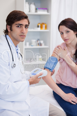 Doctor examining patients blood pressure
