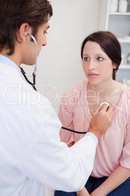 Doctor taking his patients heart beat