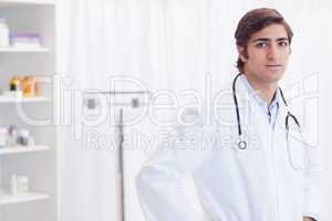 Young doctor standing in his examination room